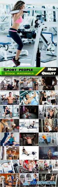 People with perfect body working on fitness machine in gym, sporting man and woman with muscles, bodybuilders Stock images